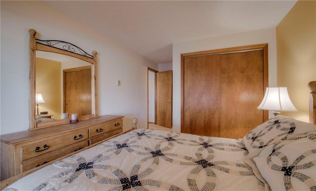 4811 Ryan Gulch Road, Unit 4811 Silverthorne, CO 80498 - Photo 23 of 35 a bedroom with a bed and a mirror