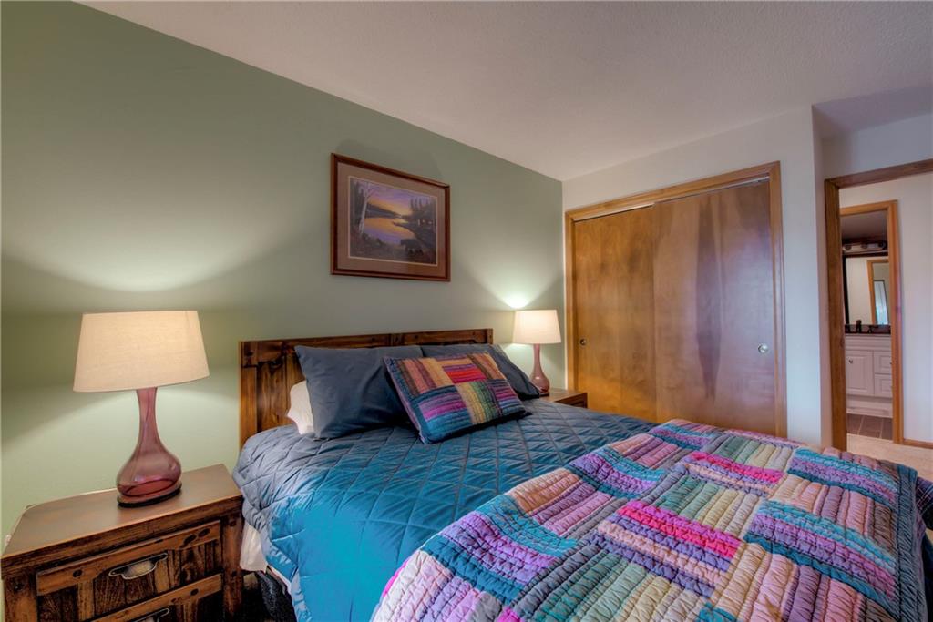4811 Ryan Gulch Road, Unit 4811 Silverthorne, CO 80498 - Photo 24 of 35 a bedroom with a bed and a lamp on table