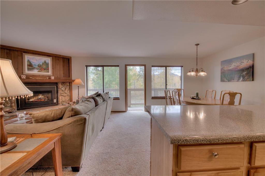 4811 Ryan Gulch Road, Unit 4811 Silverthorne, CO 80498 - Photo 29 of 35 a living room with fireplace furniture and a large window