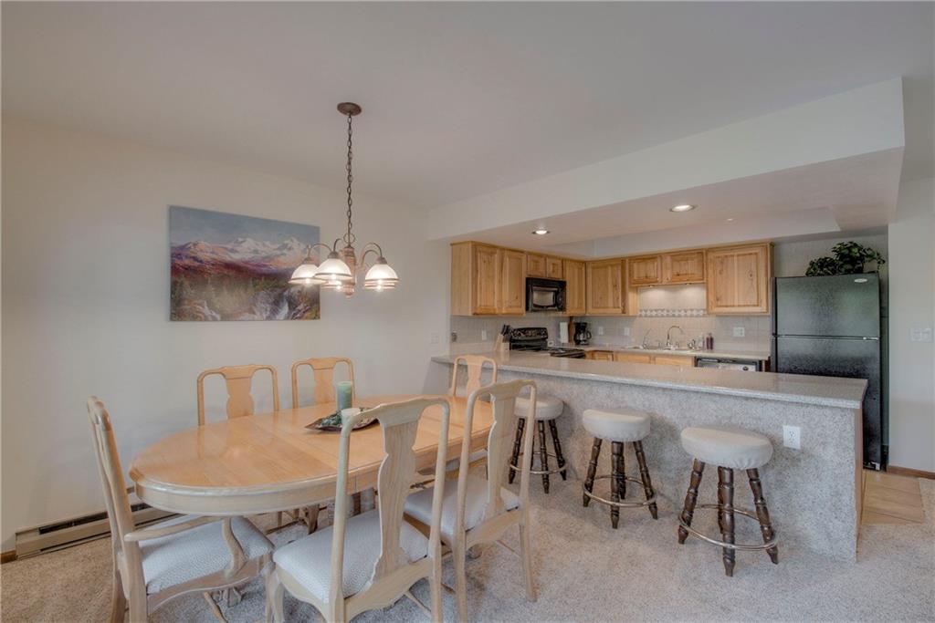 4811 Ryan Gulch Road, Unit 4811 Silverthorne, CO 80498 - Photo 4 of 35 a large kitchen with a table and chairs