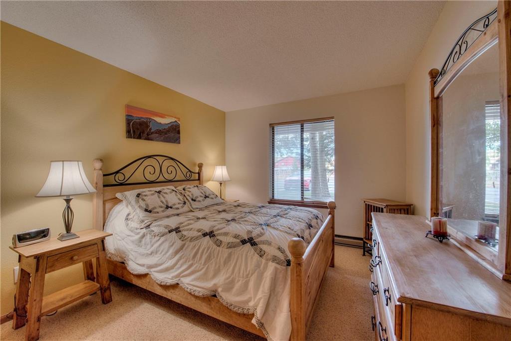 4811 Ryan Gulch Road, Unit 4811 Silverthorne, CO 80498 - Photo 5 of 35 a bedroom with a bed and a lamp on table