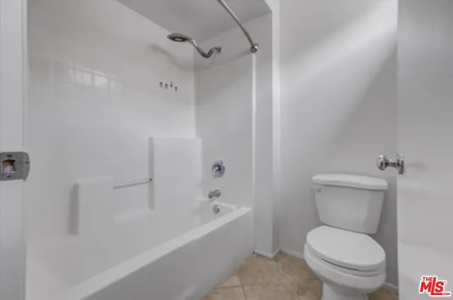 a white toilet sitting next to a bath tub