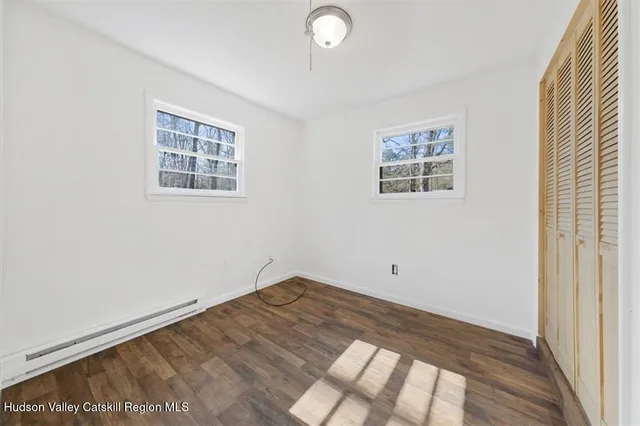 a view of empty room with wooden floor