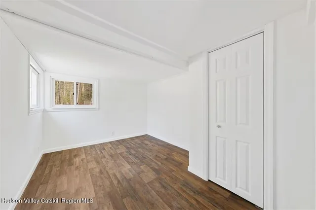 a view of a room with wooden floor and a window