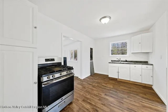 a kitchen with granite countertop a stove and a sink