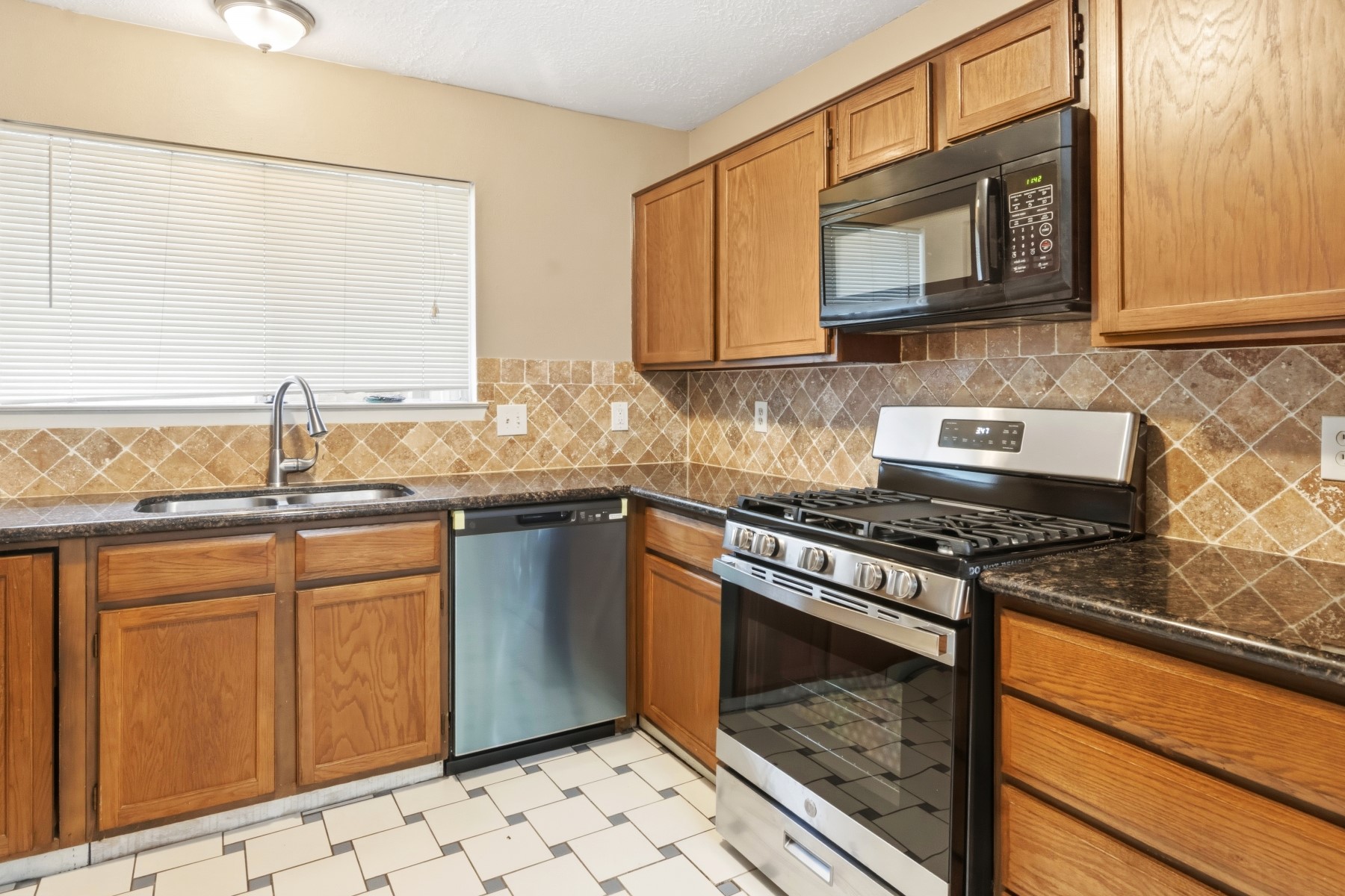 2531 North Spring Drive Spring, TX 77373 - Photo 9 of 24 a kitchen with stainless steel appliances granite countertop a stove sink and cabinets