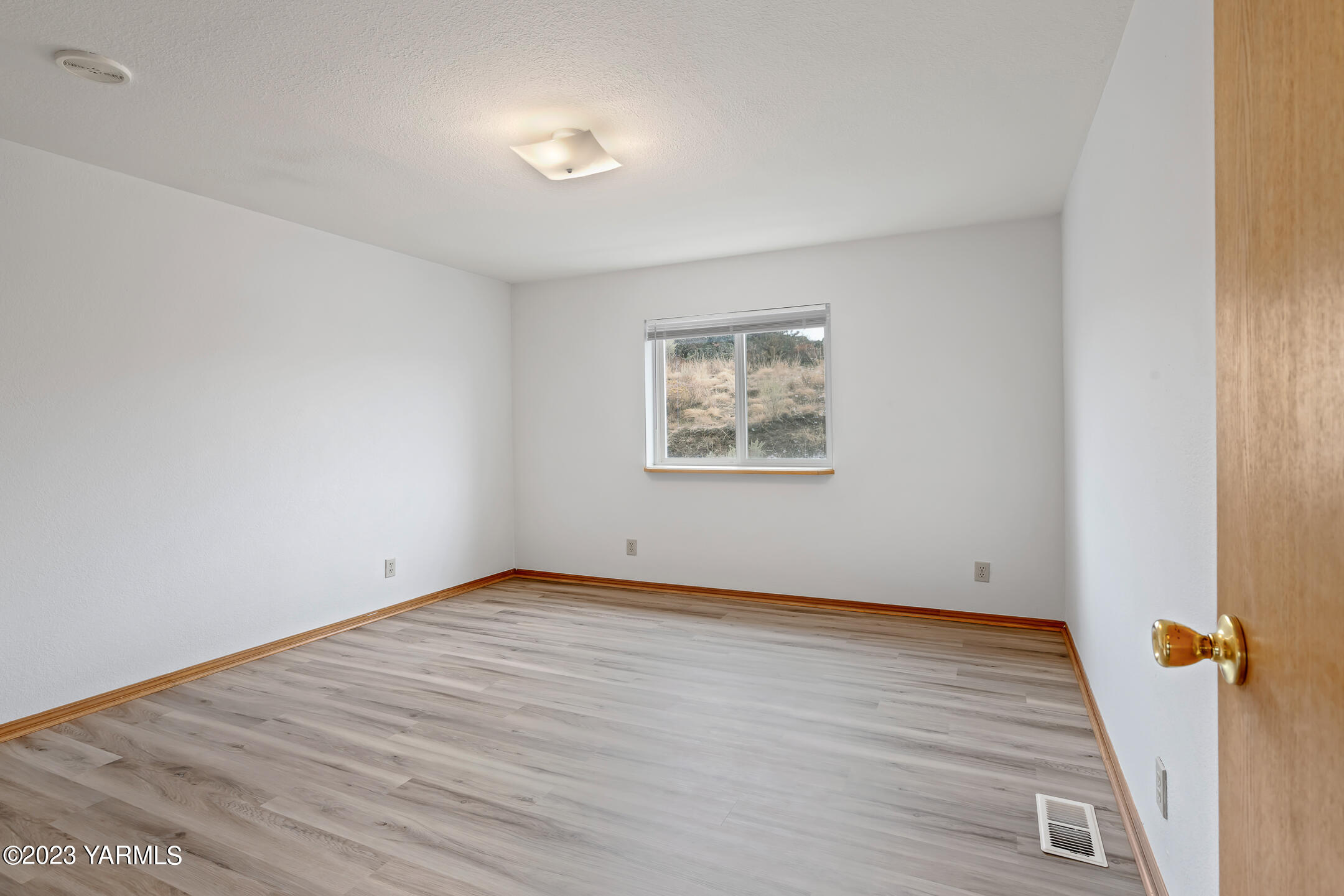 443 Hancock Road Cowiche, WA 98923 - Photo 8 of 17 an empty room with wooden floor and windows