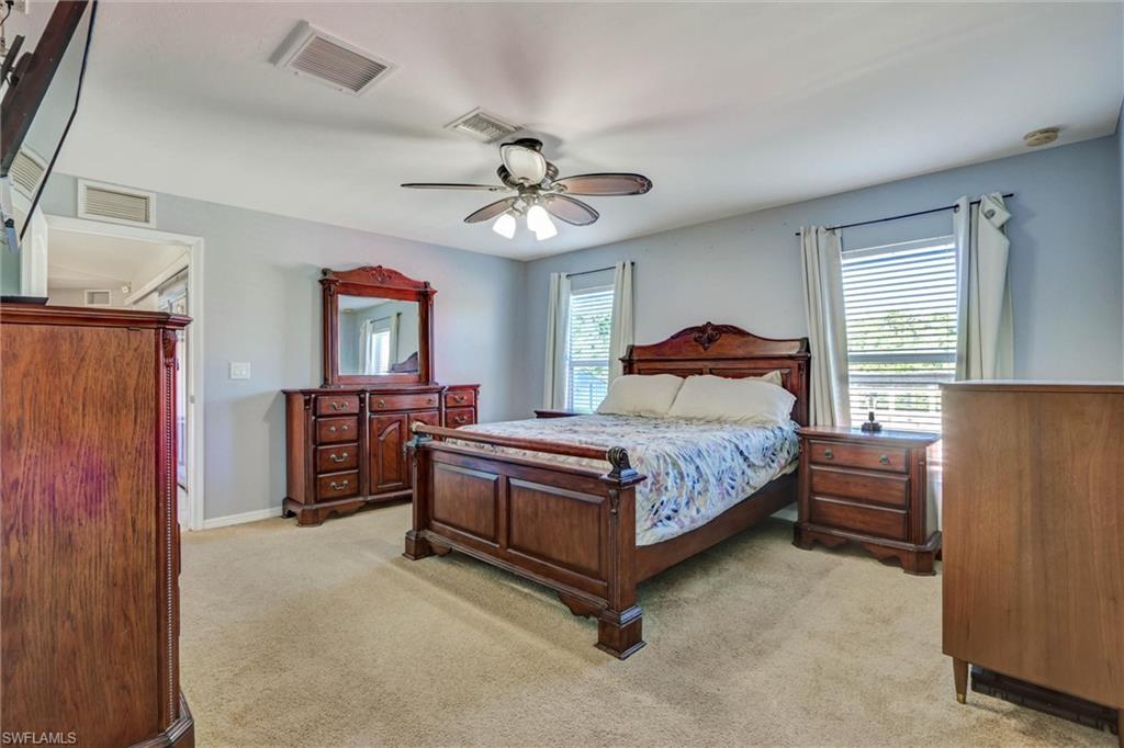 314 Rand Avenue Lehigh Acres, FL 33974 - Photo 16 of 35 a bedroom with a bed and a chandelier