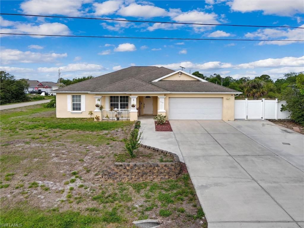 314 Rand Avenue Lehigh Acres, FL 33974 - Photo 28 of 35 a front view of a house with garden