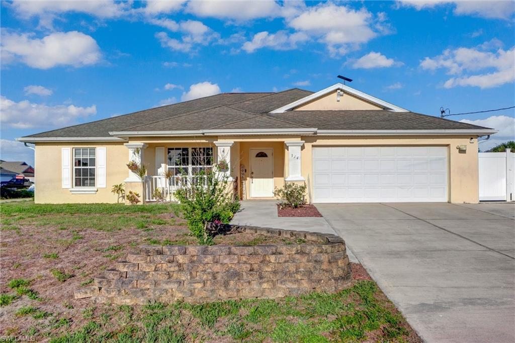 314 Rand Avenue Lehigh Acres, FL 33974 - Photo 34 of 35 a front view of a house with garden