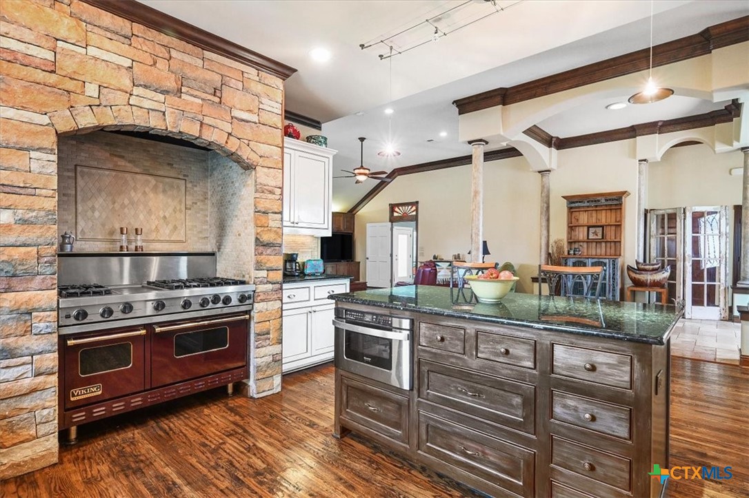 615 Benchmark Trail Belton, TX 76513 - Photo 12 of 36 a kitchen with stainless steel appliances kitchen island granite countertop a stove and a sink