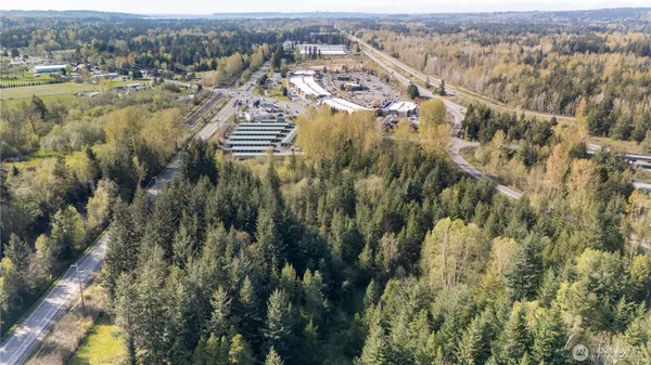 an aerial view of residential houses with outdoor space and trees