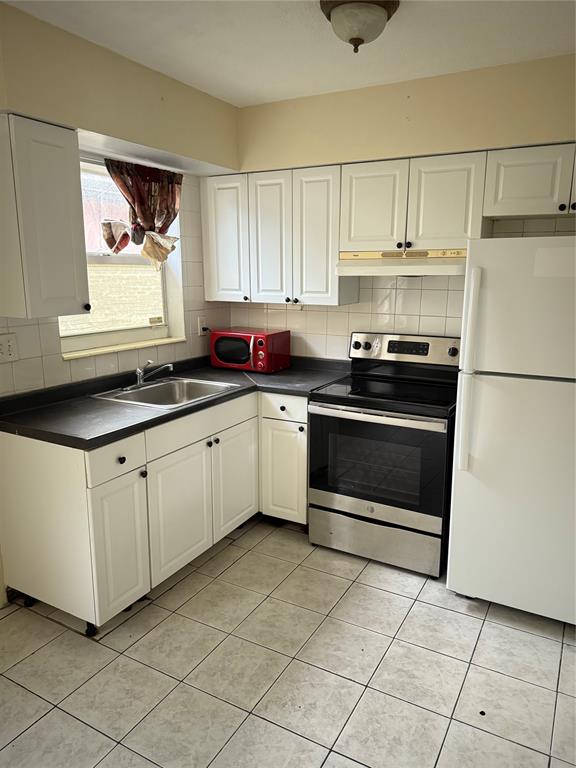 1477 Northwest 60th Avenue, Unit 2 Sunrise, FL 33313 - Photo 2 of 7 a kitchen with stainless steel appliances a stove a sink and a refrigerator