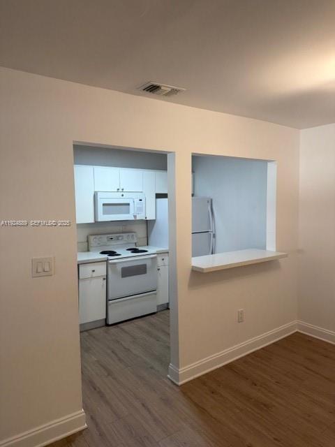 12960 Southwest 66th Lane, Unit 1031 Miami, FL 33183 - Photo 2 of 7 a kitchen with wooden floors and white appliances