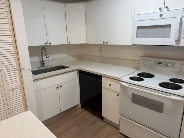a kitchen with a sink stove and cabinets