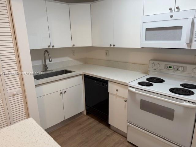 12960 Southwest 66th Lane, Unit 1031 Miami, FL 33183 - Photo 4 of 7 a kitchen with a sink stove and cabinets