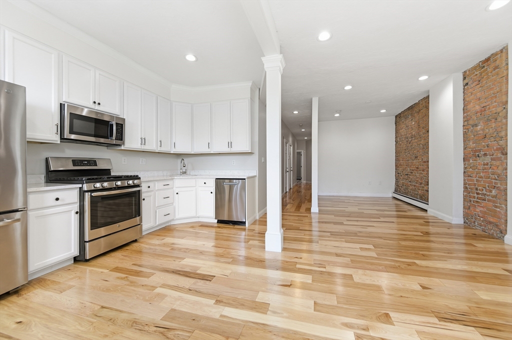 54 Beacon Street, Unit 2 Chelsea, MA 02150 - Photo 3 of 26 a kitchen with stainless steel appliances granite countertop a stove a sink and a refrigerator