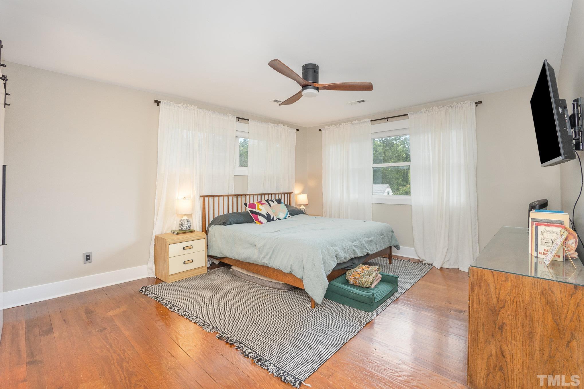 719 New Road Raleigh, NC 27608 - Photo 21 of 38 a bedroom with a bed and a tv on the dresser