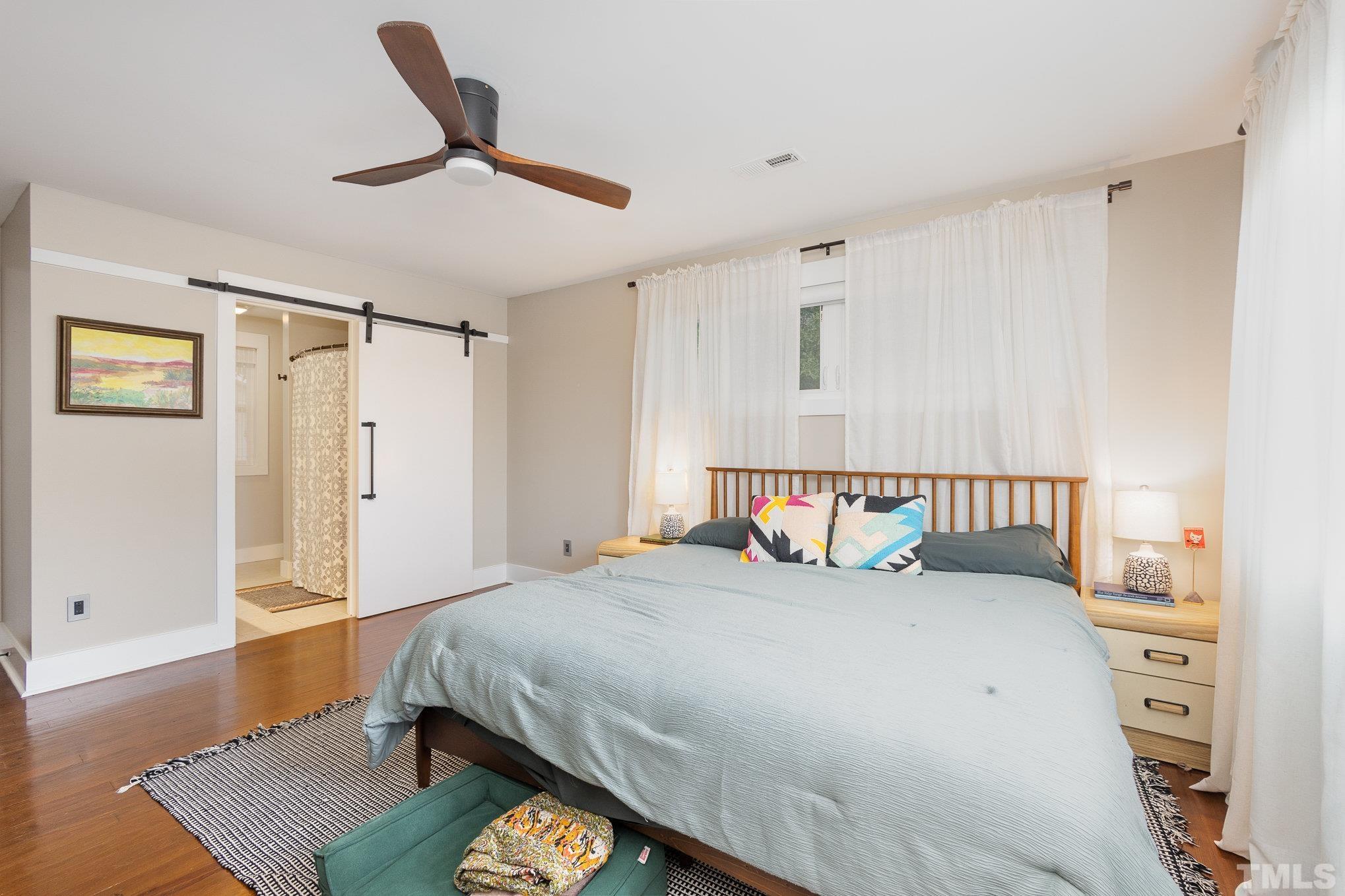 719 New Road Raleigh, NC 27608 - Photo 22 of 38 a bedroom with a bed and a table in it