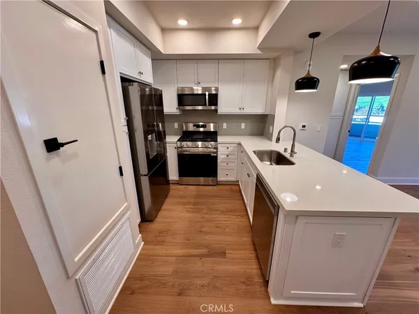 a kitchen with stainless steel appliances a refrigerator a sink a stove top oven a refrigerator and cabinets