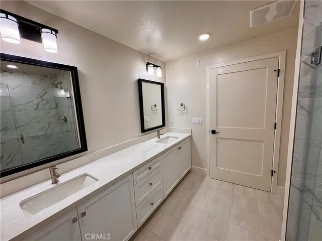 a bathroom with a double vanity sink and a mirror