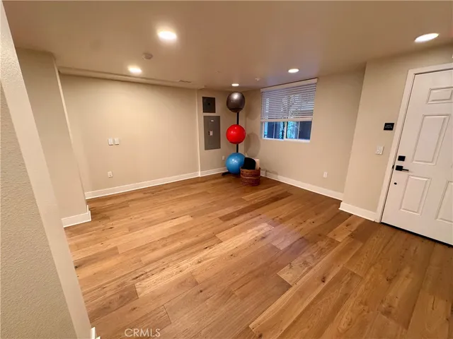 a view of an empty room with wooden floor and entryway
