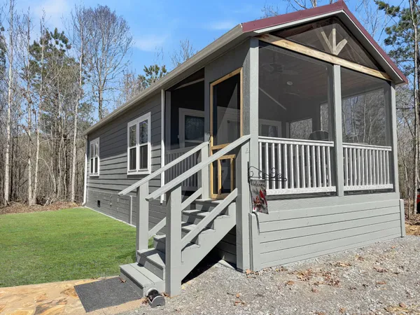 a view of wooden house with a yard