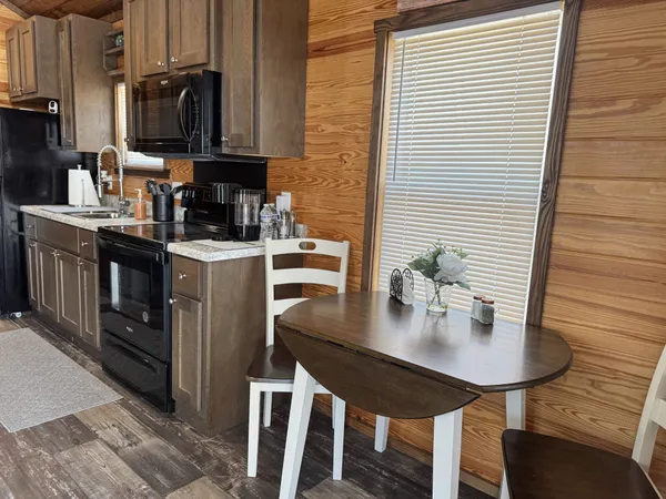 a kitchen with stainless steel appliances a sink a table and chairs