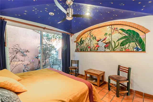 a bedroom with a bed and a painting on the wall