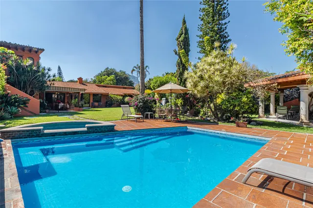 a view of swimming pool with lawn chairs and plants