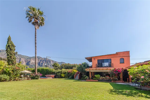 a front view of a house with a yard and swimming pool