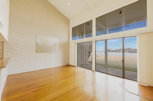 a view of an empty room with window and wooden floor