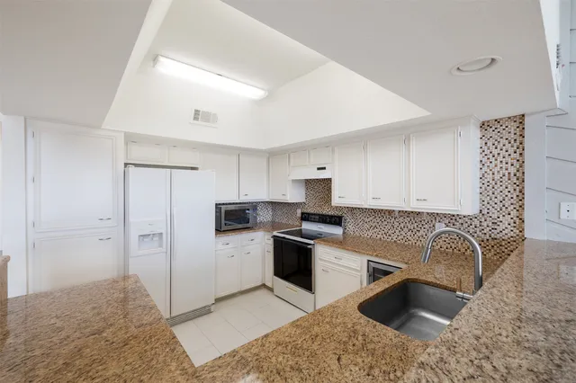 a bathroom with a tub sink vanity and mirror