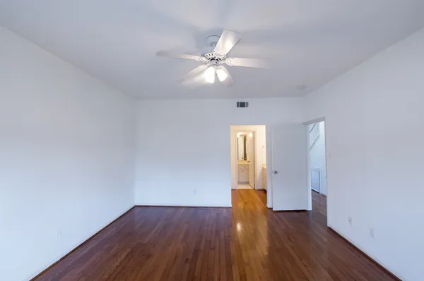 a view of an empty room with a chandelier fan