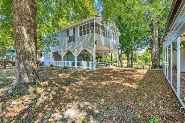 a view of a house with backyard and tree