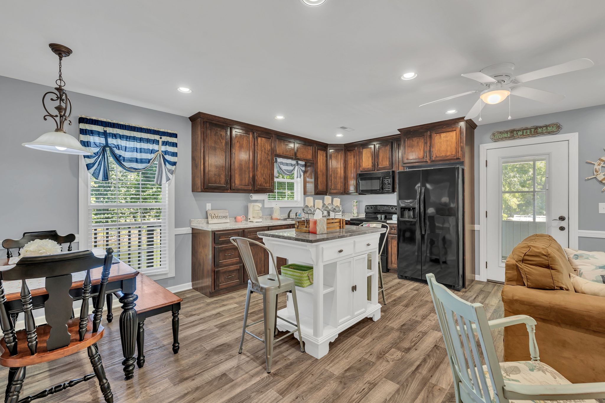 219 Tn River Estates Road Clifton, TN 38425 - Photo 15 of 38 a kitchen with stainless steel appliances granite countertop a refrigerator a stove top oven a sink dishwasher and a dining table with wooden floor