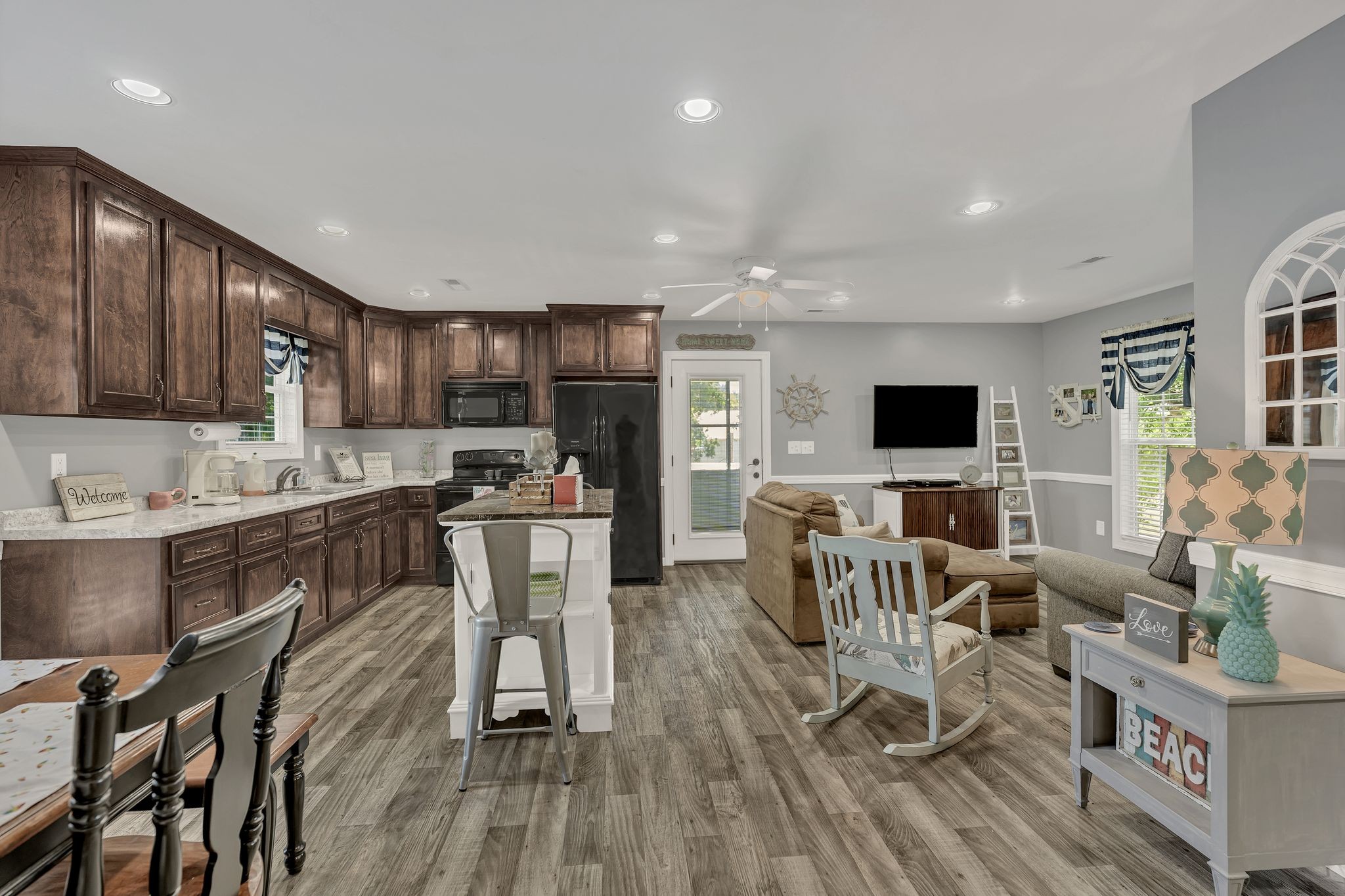 219 Tn River Estates Road Clifton, TN 38425 - Photo 9 of 38 a kitchen with stainless steel appliances granite countertop a stove top oven a sink dishwasher a dining table and chairs with wooden floor