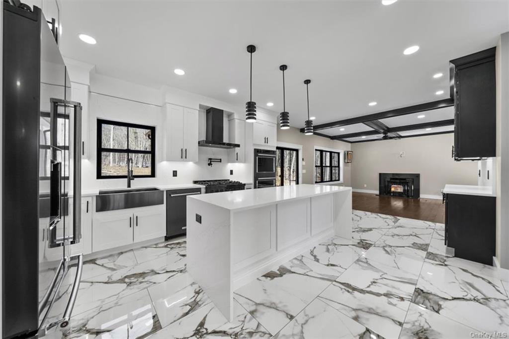 346 Shawanga Lodge Road Bloomingburg, NY 12721 - Photo 12 of 36 Kitchen with white cabinetry, sink, wall chimney range hood, and a center island