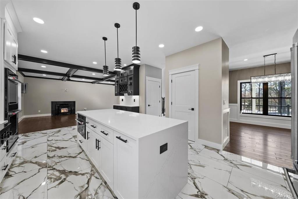 346 Shawanga Lodge Road Bloomingburg, NY 12721 - Photo 14 of 36 Kitchen featuring white cabinets, decorative light fixtures, light hardwood / wood-style flooring, and a kitchen island