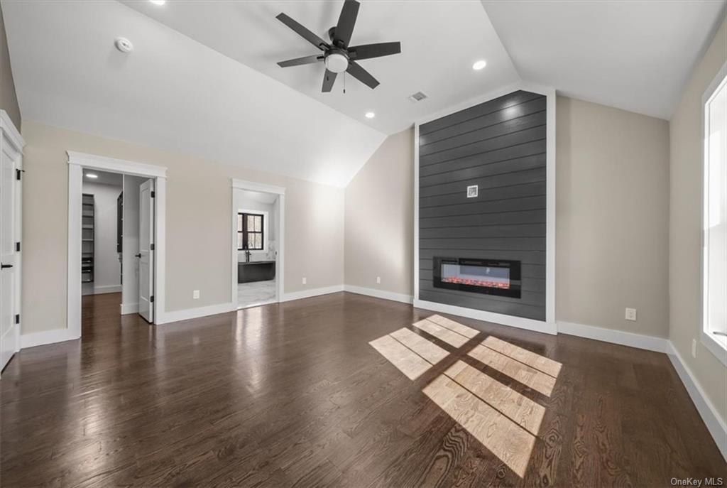 346 Shawanga Lodge Road Bloomingburg, NY 12721 - Photo 20 of 36 Unfurnished living room featuring vaulted ceiling, ceiling fan, a fireplace, and dark hardwood / wood-style flooring