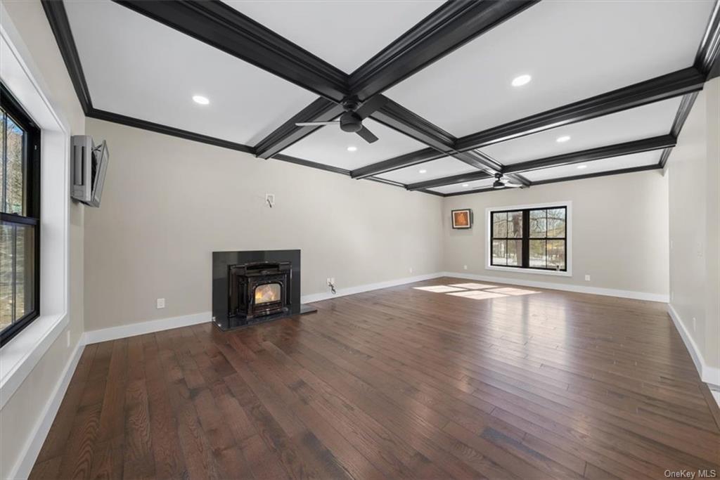 346 Shawanga Lodge Road Bloomingburg, NY 12721 - Photo 6 of 36 Unfurnished living room with a wealth of natural light, dark wood-type flooring, ceiling fan, and a fireplace