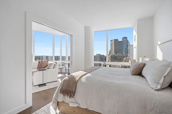 a bedroom with a bed and large window