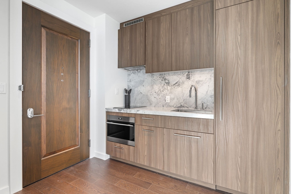 40 Trinity Place, Unit 1508 Boston, MA 02116 - Photo 8 of 19 a kitchen with granite countertop white cabinets and stainless steel appliances