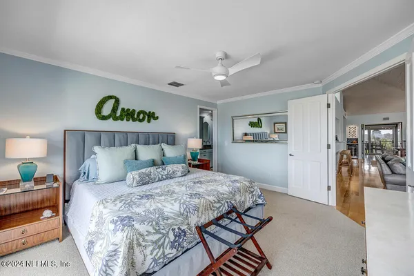 a bedroom with a large bed and a chandelier
