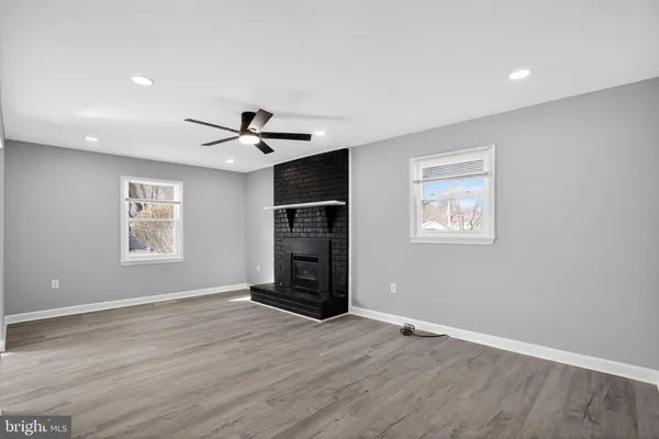 a view of empty room with wooden floor and ceiling fan