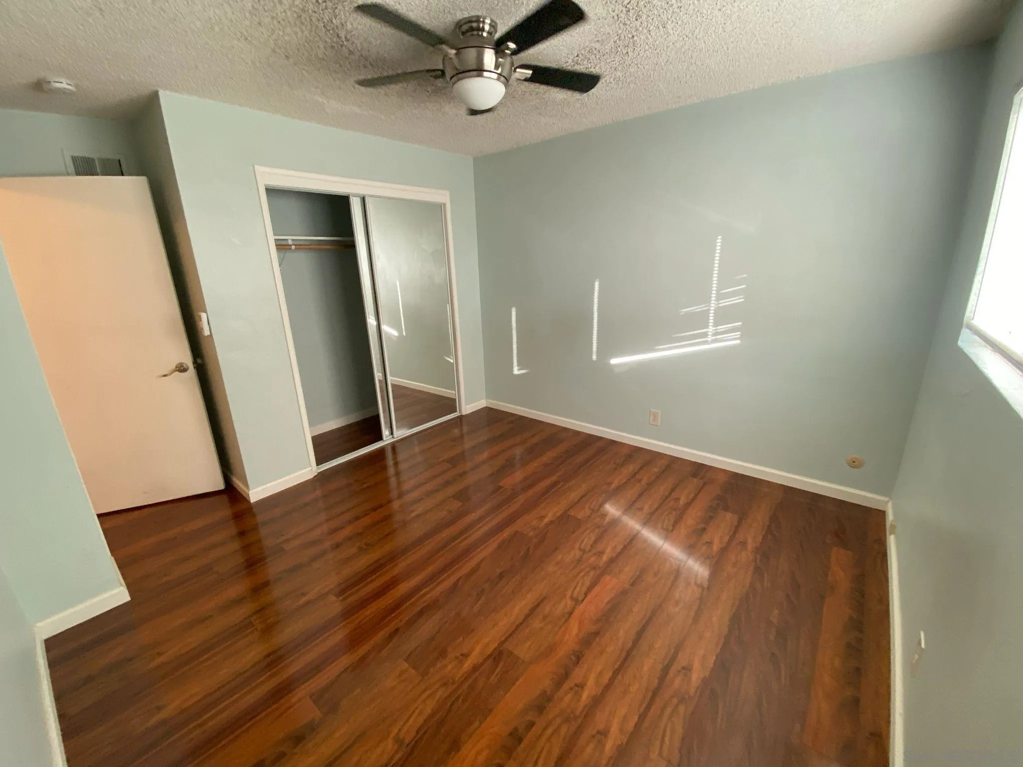 253 North Cedar Street Escondido, CA 92025 - Photo 16 of 18 an empty room with wooden floor fan and windows