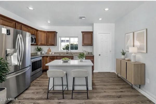 a kitchen with stainless steel appliances kitchen island granite countertop a refrigerator and a stove top oven
