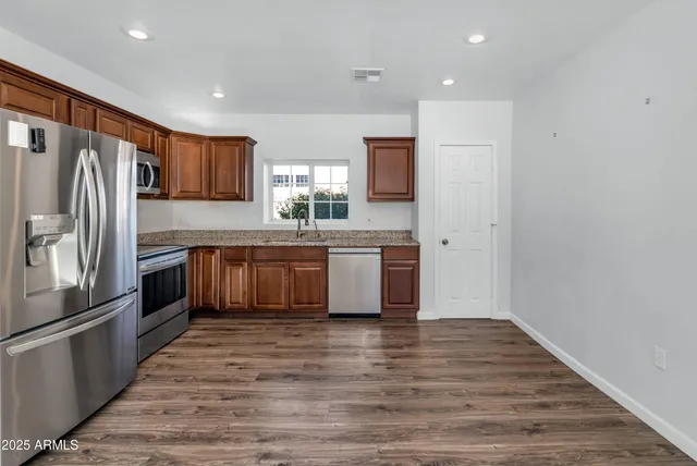 a large kitchen with a large counter top stainless steel appliances and cabinets