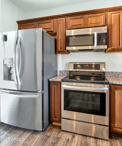 a kitchen with stainless steel appliances granite countertop a stove microwave and refrigerator