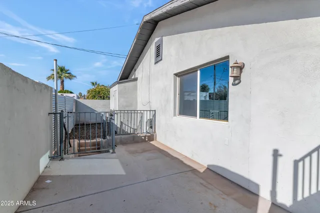 a view of a small house with wooden fence